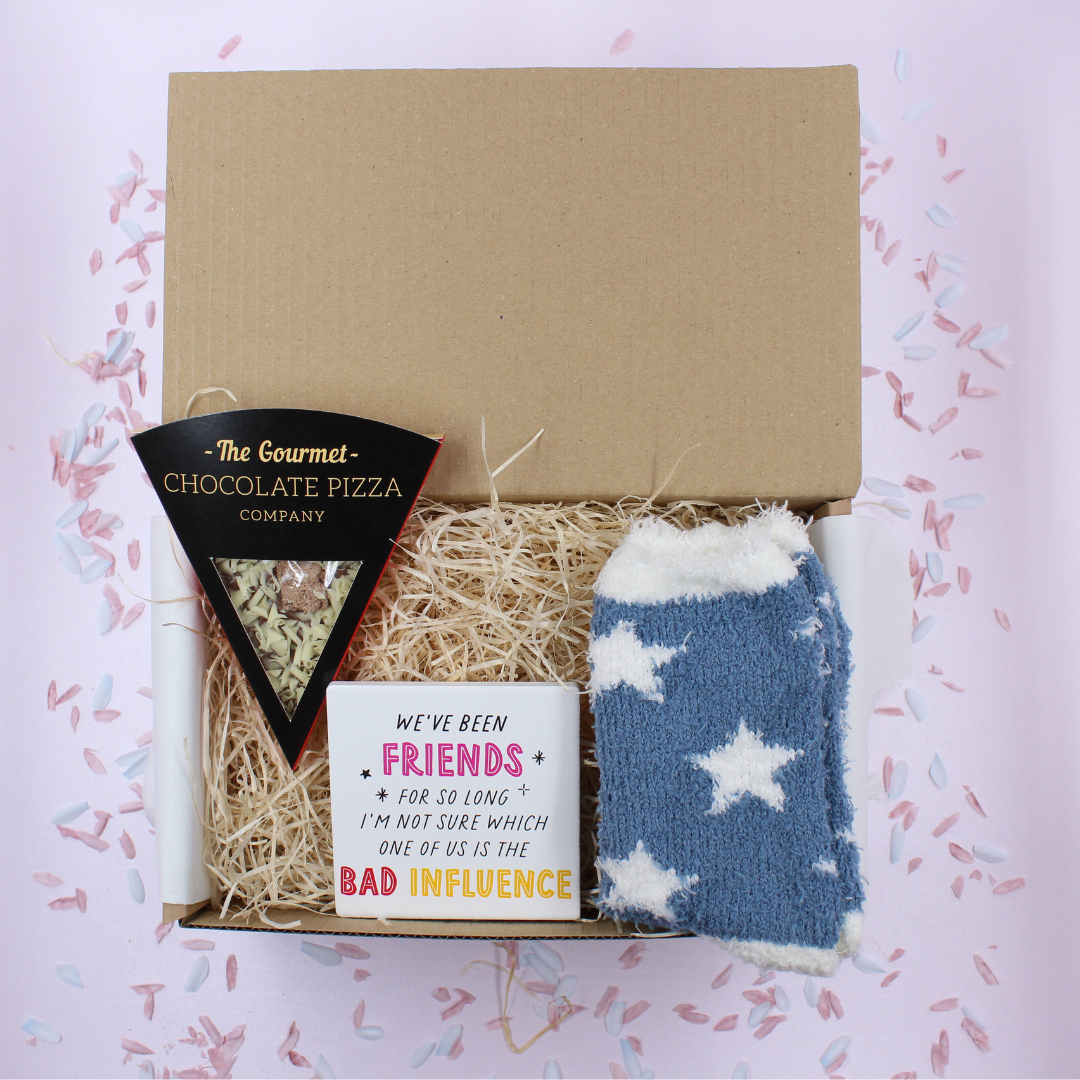 Friend Treat Box with chocolate pizza slice, denim blue cosy socks, and Friends Bad Influence coaster