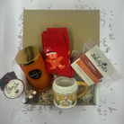 Christmas gingerbread treat box with candle, mug, socks, popcorn, and hot chocolate